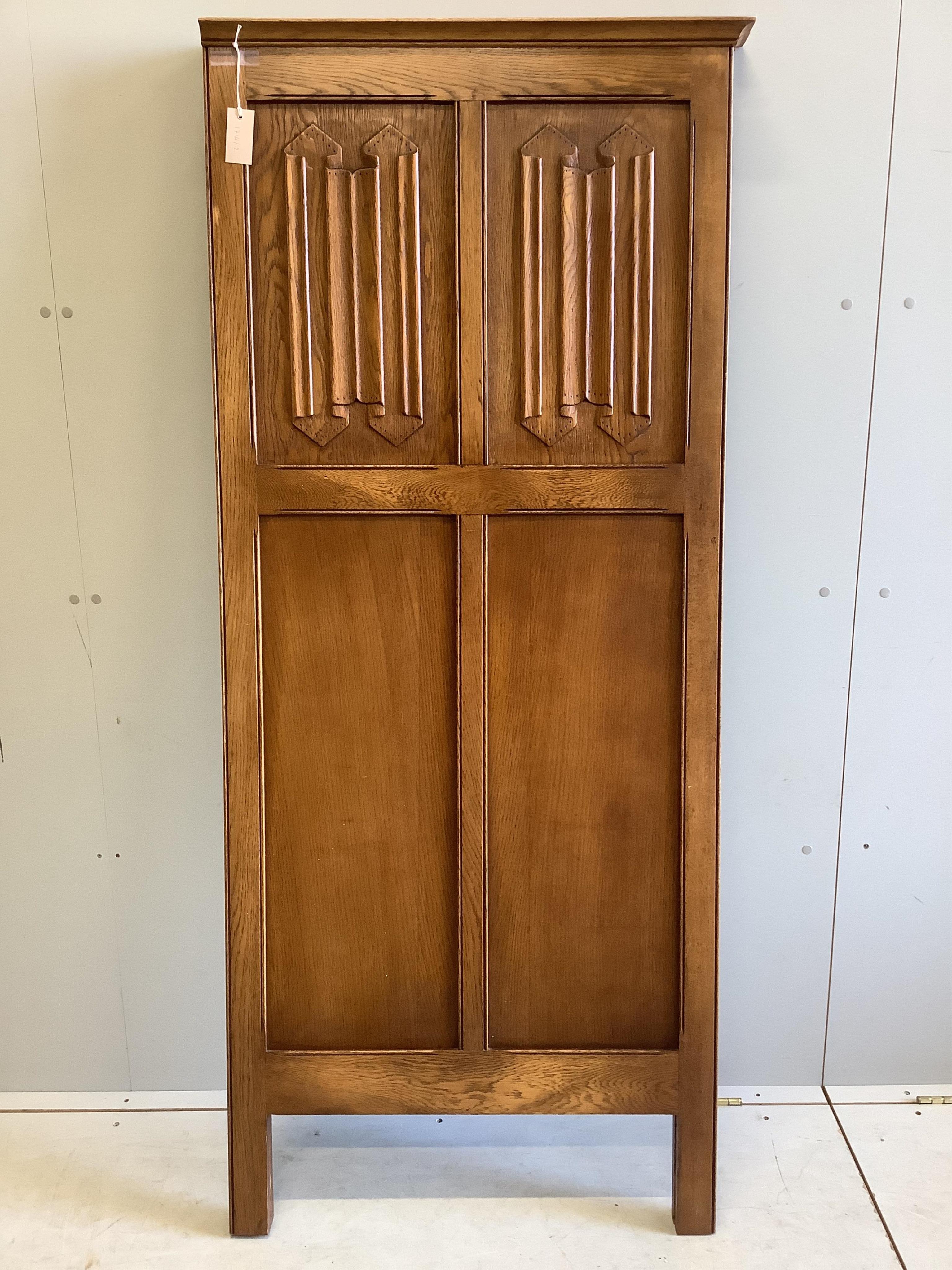 An early 20th century carved oak linen fold two fold dressing screen, each panel width 73cm, height 170cm. Condition - good